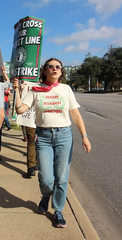 A photo of Gigs on the Starbucks picket line at 45th & Lamar with a sign that says "Don't cross our picket line - ULP strike"